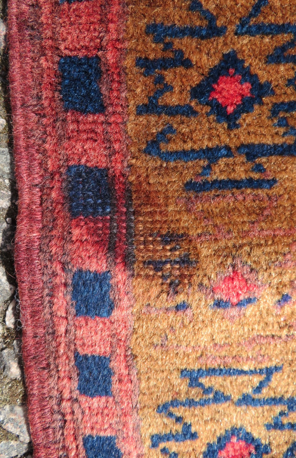 A handwoven Turkish wool rug featuring three central red star medallions on a dark navy blue field with geometric borders in ochre brown. View VIII