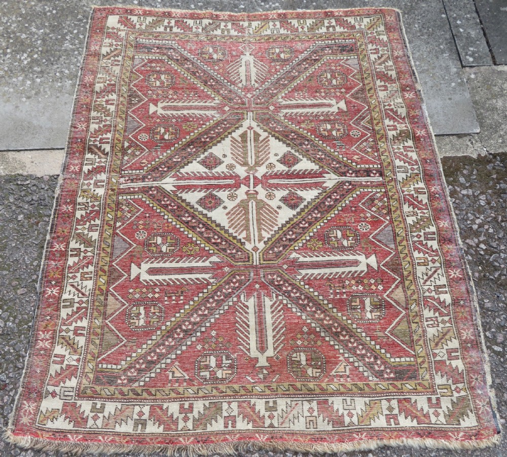 An antique hand-knotted Shirvan wool rug featuring a central diamond medallion, geometric motifs, and detailed borders in shades of red, cream, and brown. View XV