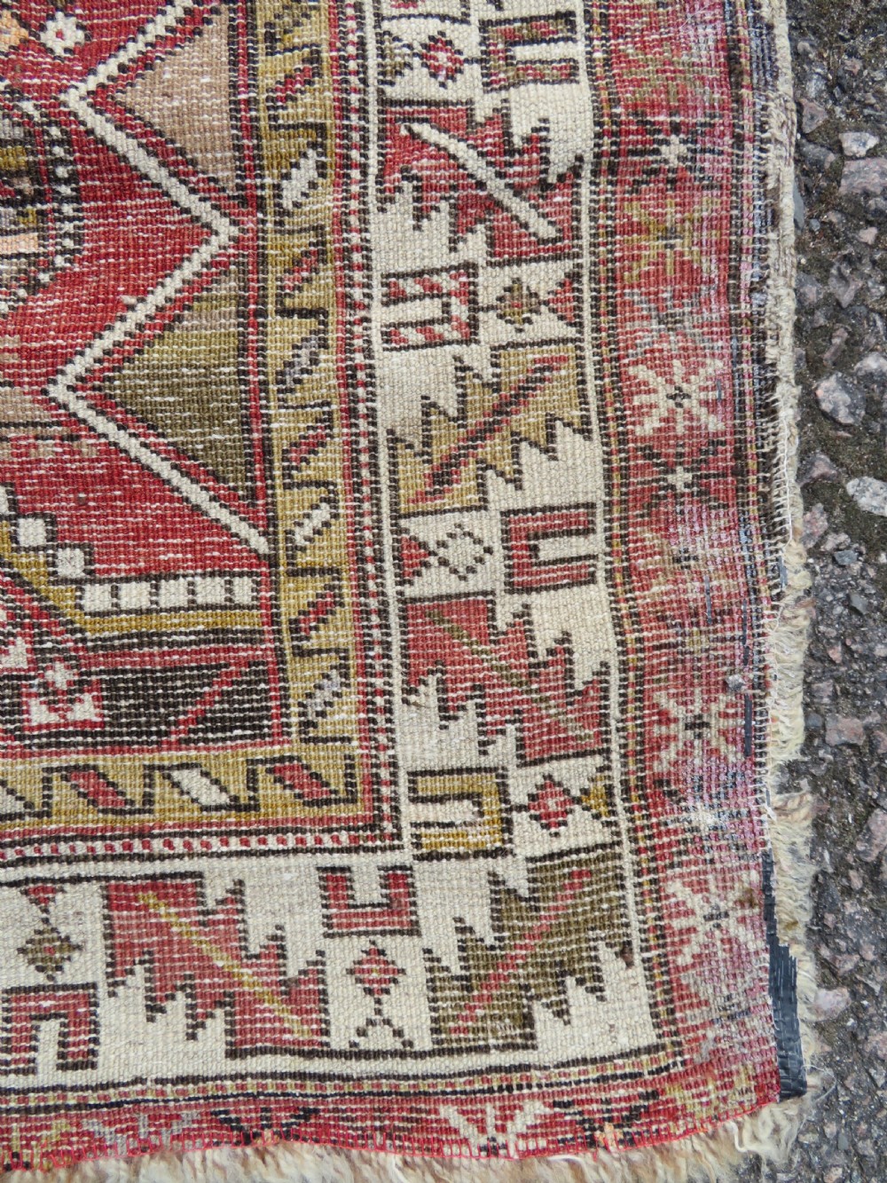 An antique hand-knotted Shirvan wool rug featuring a central diamond medallion, geometric motifs, and detailed borders in shades of red, cream, and brown. View XVI