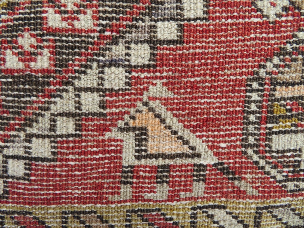An antique hand-knotted Shirvan wool rug featuring a central diamond medallion, geometric motifs, and detailed borders in shades of red, cream, and brown. View XVII