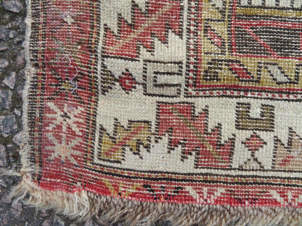 An antique hand-knotted Shirvan wool rug featuring a central diamond medallion, geometric motifs, and detailed borders in shades of red, cream, and brown. View XVIII