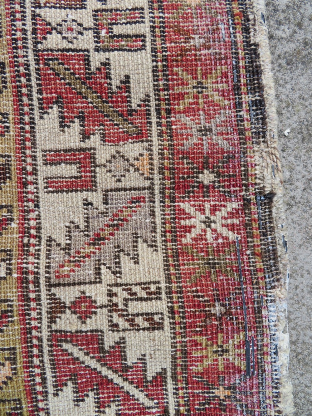 An antique hand-knotted Shirvan wool rug featuring a central diamond medallion, geometric motifs, and detailed borders in shades of red, cream, and brown. View XIX