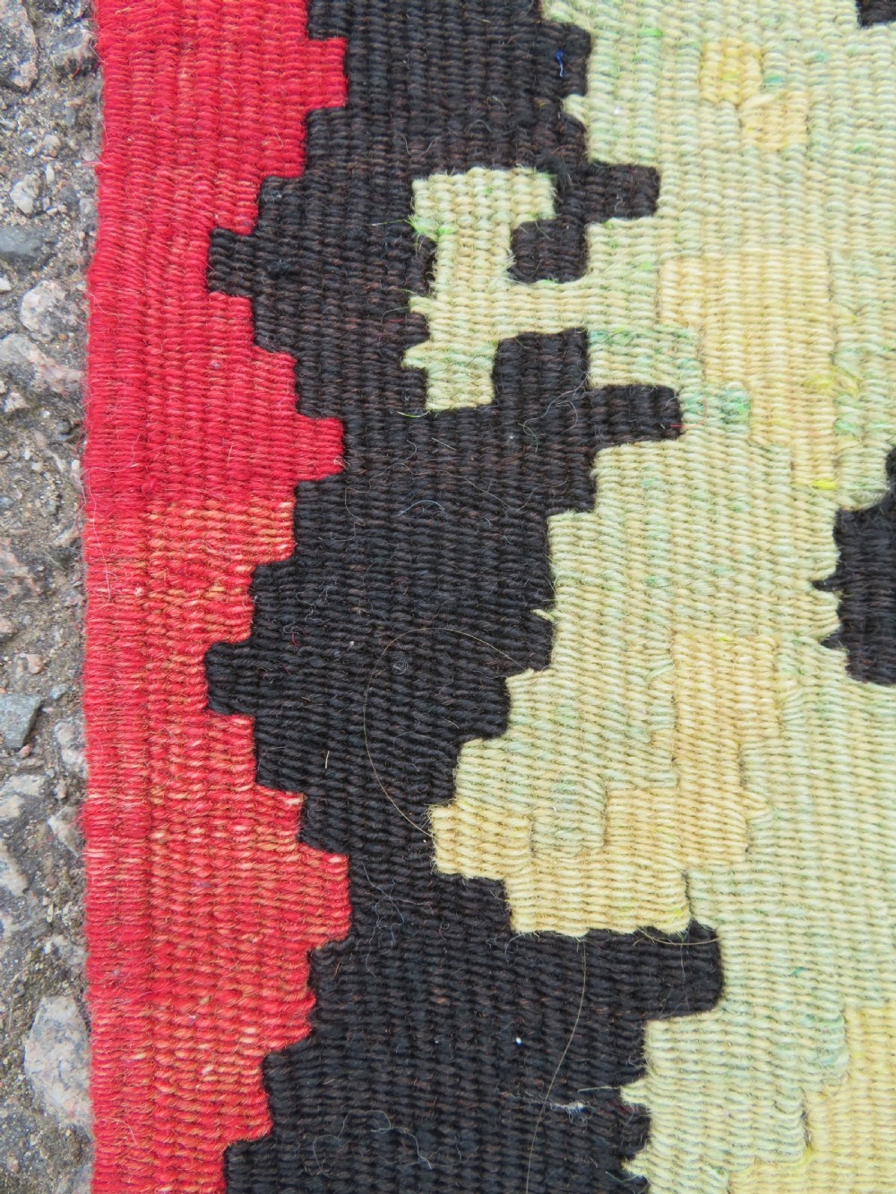 An antique flatweave wool rug featuring a central red panel with blue floral motifs, bordered by dark navy and cream botanical patterns. View XV