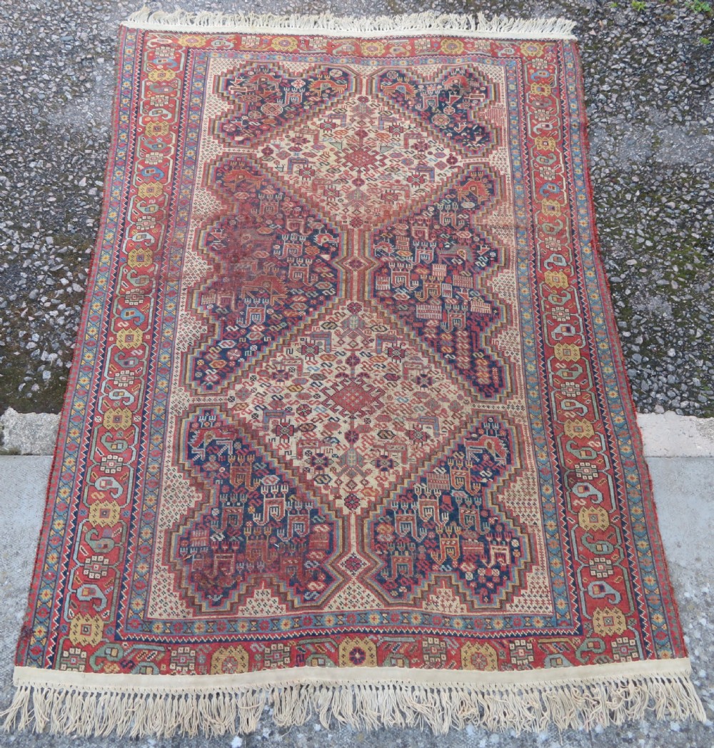 An antique Khamseh nomadic wool rug featuring complex geometric medallions, bird motifs, and multi-layered borders in terracotta, navy blue, and cream. View II