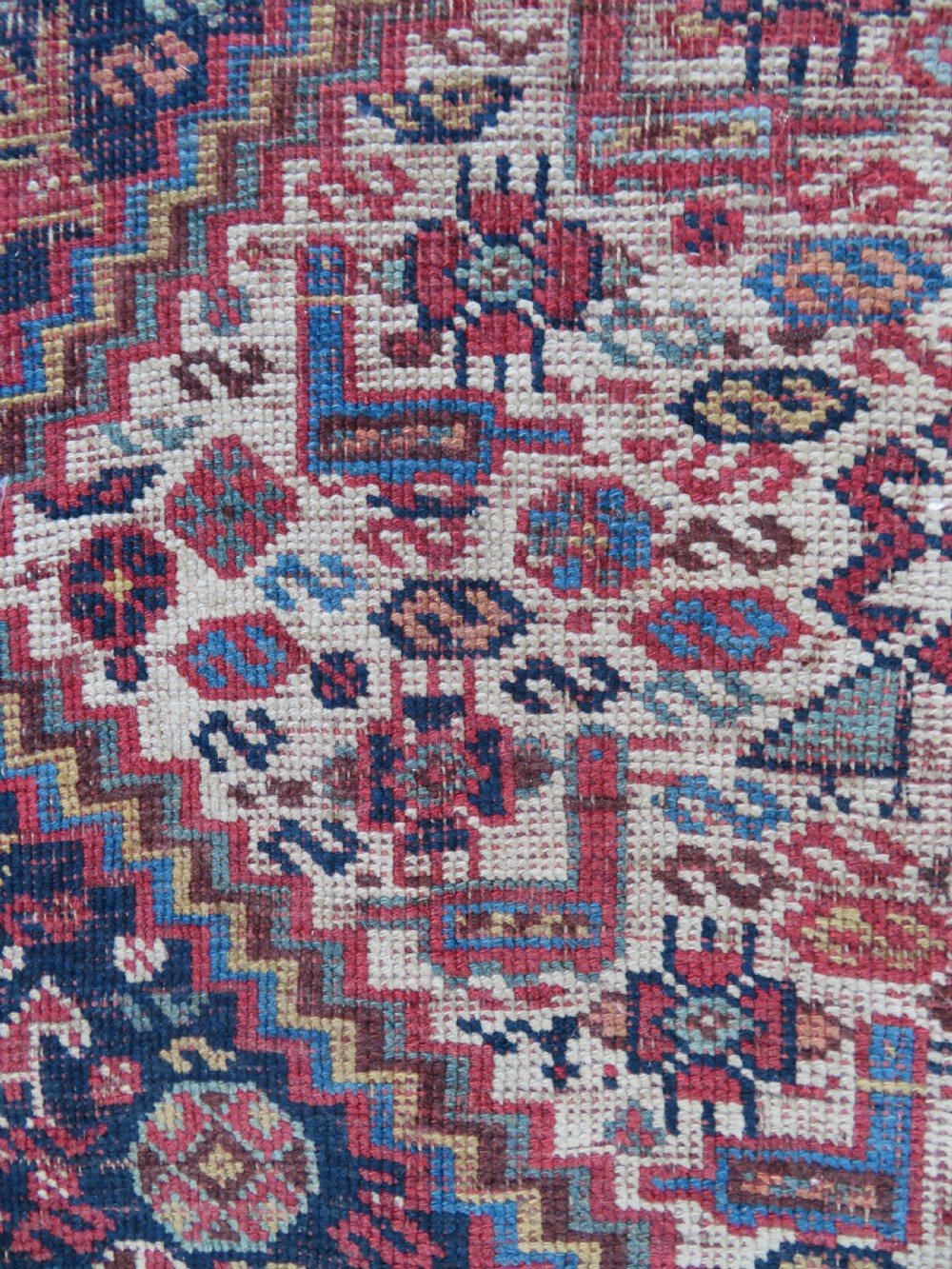 An antique Khamseh nomadic wool rug featuring complex geometric medallions, bird motifs, and multi-layered borders in terracotta, navy blue, and cream. View VIII