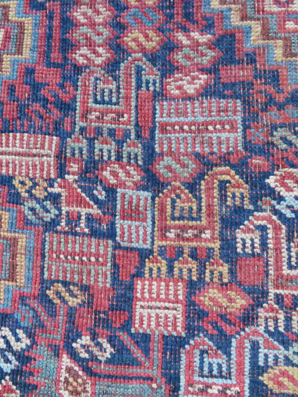An antique Khamseh nomadic wool rug featuring complex geometric medallions, bird motifs, and multi-layered borders in terracotta, navy blue, and cream. View XII