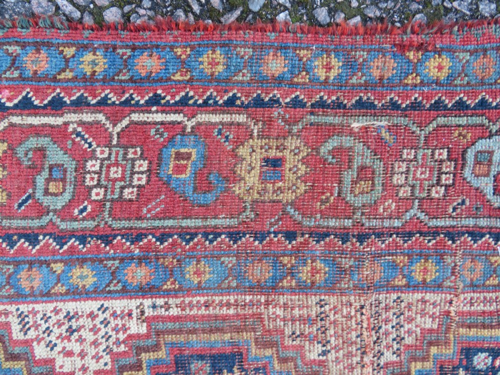 An antique Khamseh nomadic wool rug featuring complex geometric medallions, bird motifs, and multi-layered borders in terracotta, navy blue, and cream. View XVIII