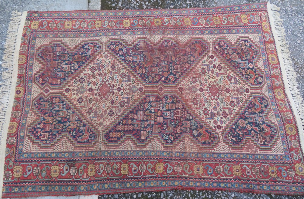 An antique Khamseh nomadic wool rug featuring complex geometric medallions, bird motifs, and multi-layered borders in terracotta, navy blue, and cream. View XIX