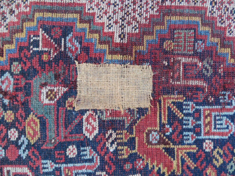 An antique Khamseh nomadic wool rug featuring complex geometric medallions, bird motifs, and multi-layered borders in terracotta, navy blue, and cream. View XXII