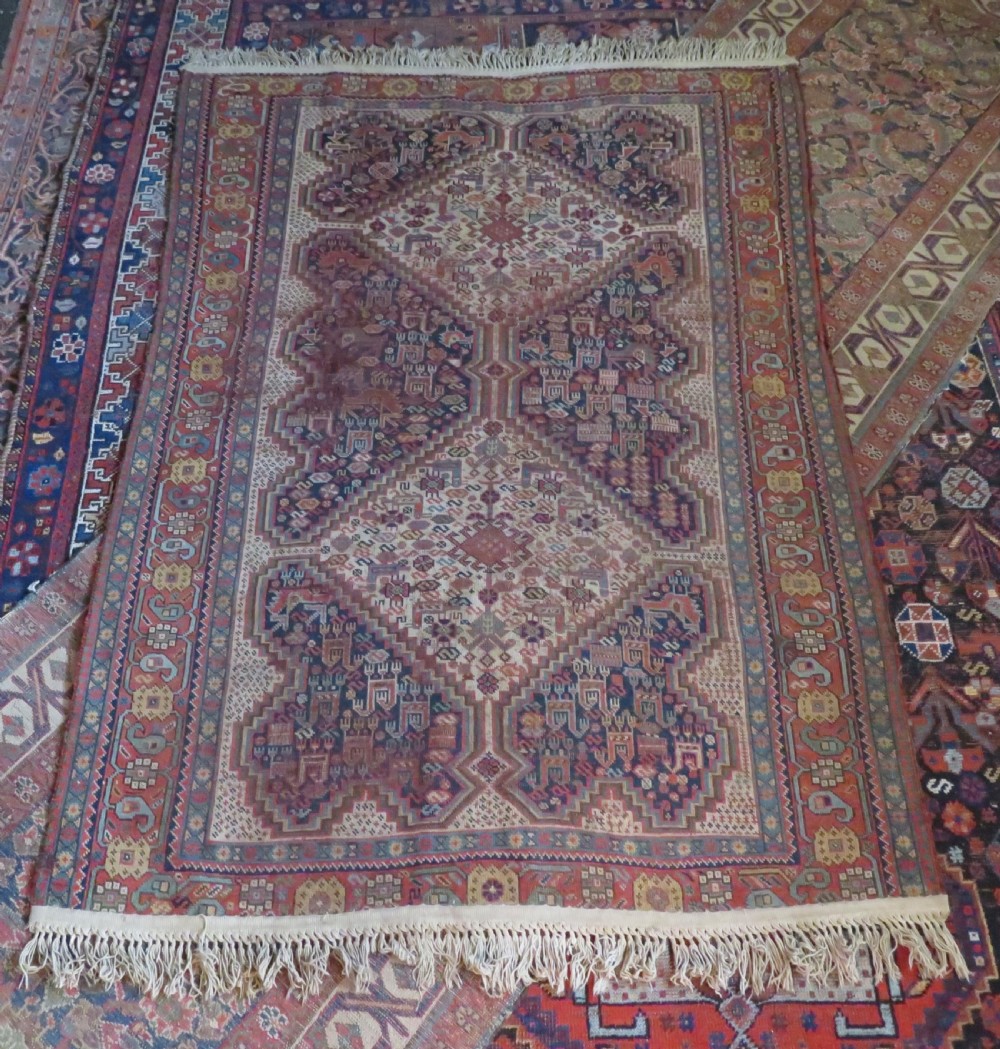 An antique Khamseh nomadic wool rug featuring complex geometric medallions, bird motifs, and multi-layered borders in terracotta, navy blue, and cream. View XXV