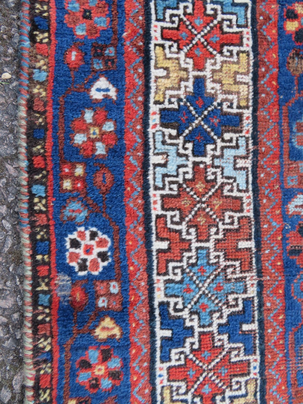 An antique Persian Khamseh wool carpet featuring a dark navy blue field with three stacked diamond medallions and geometric borders in terracotta red and ivory. View XXII