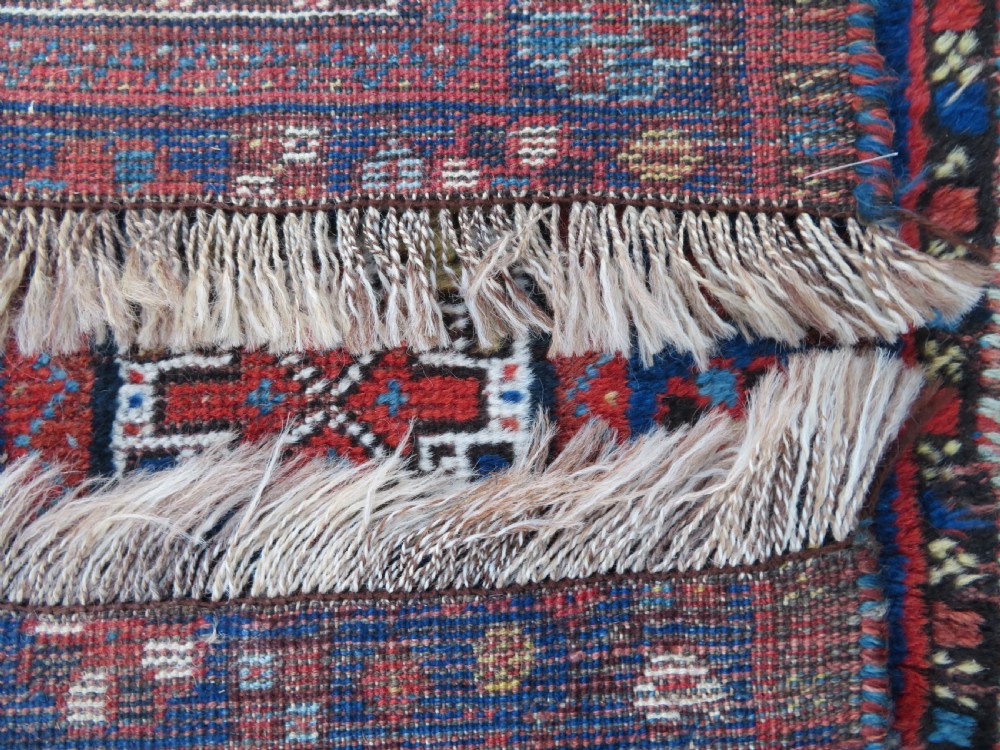 An antique Persian Khamseh wool carpet featuring a dark navy blue field with three stacked diamond medallions and geometric borders in terracotta red and ivory. View XXVI
