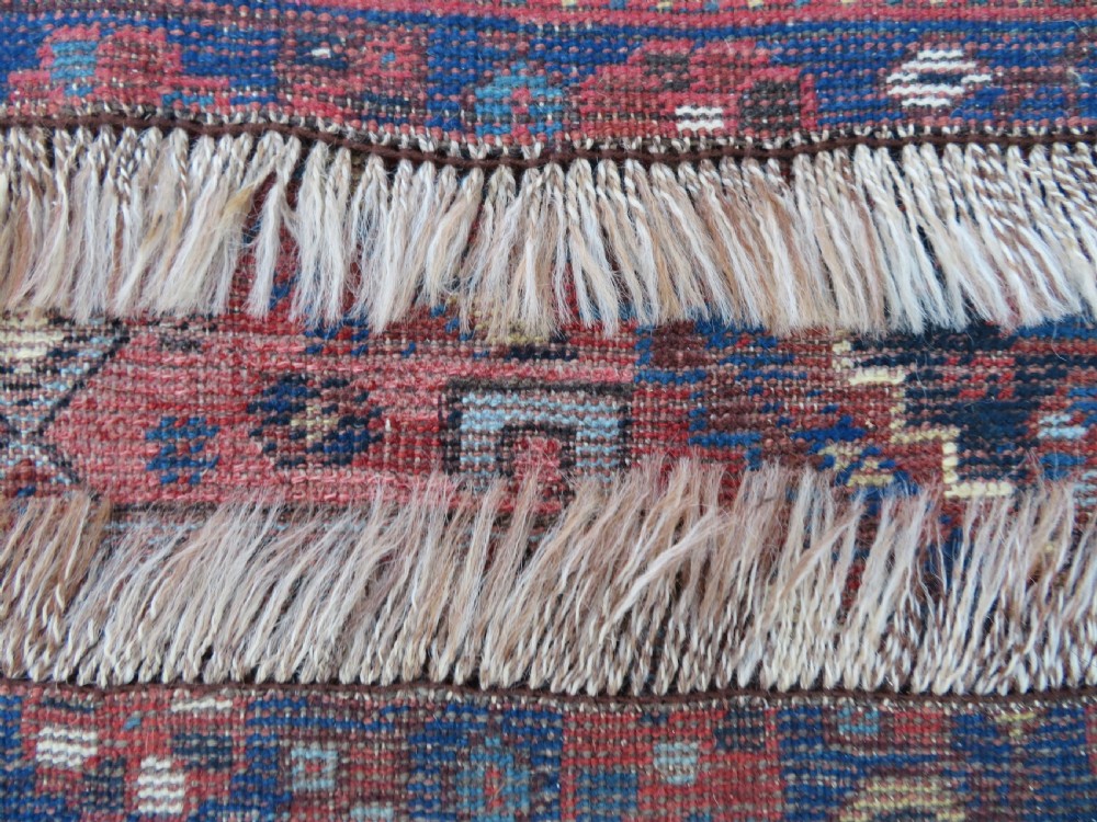An antique Persian Khamseh wool carpet featuring a dark navy blue field with three stacked diamond medallions and geometric borders in terracotta red and ivory. View XXVII