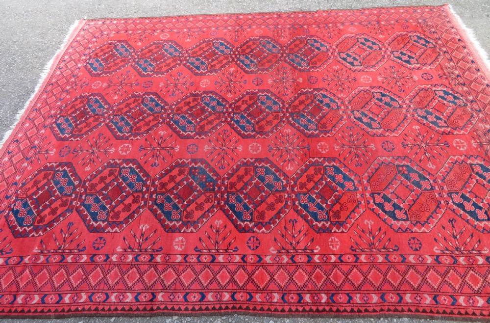 A large hand-knotted red wool Ersari carpet featuring repeating octagonal gul motifs and geometric border bands. View III