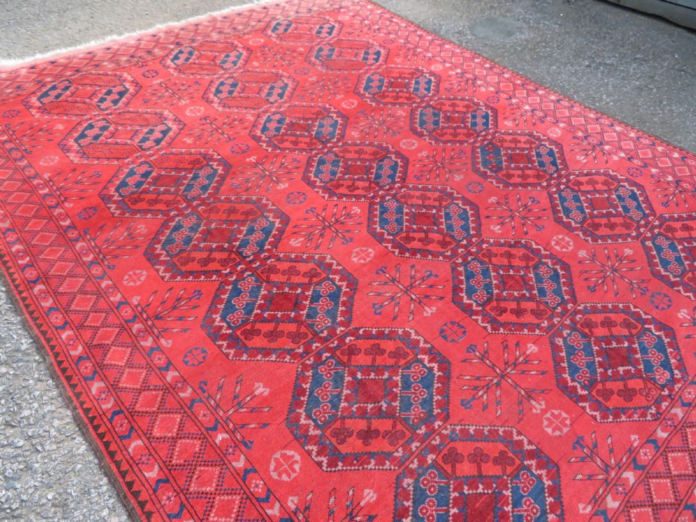 A large hand-knotted red wool Ersari carpet featuring repeating octagonal gul motifs and geometric border bands. View IV