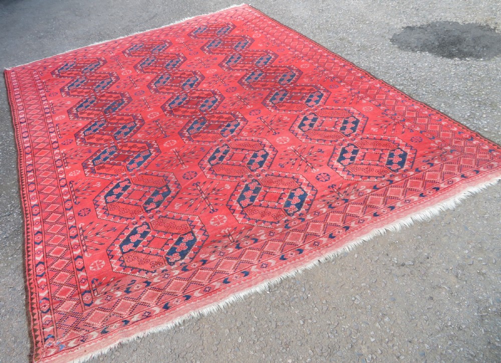 A large hand-knotted red wool Ersari carpet featuring repeating octagonal gul motifs and geometric border bands. View V
