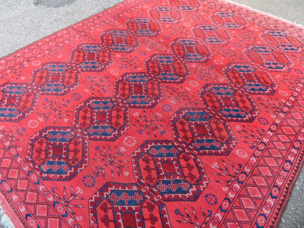 A large hand-knotted red wool Ersari carpet featuring repeating octagonal gul motifs and geometric border bands. View VI