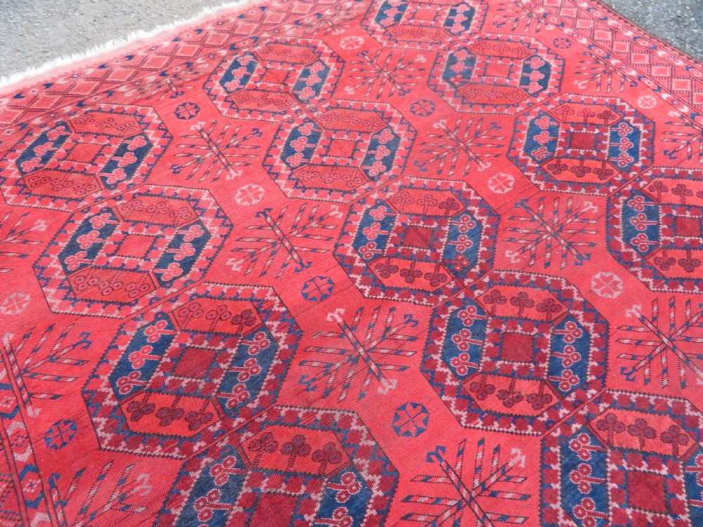 A large hand-knotted red wool Ersari carpet featuring repeating octagonal gul motifs and geometric border bands. View VIII