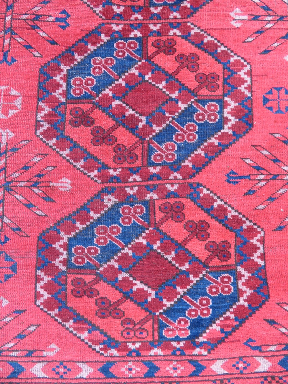 A large hand-knotted red wool Ersari carpet featuring repeating octagonal gul motifs and geometric border bands. View XI