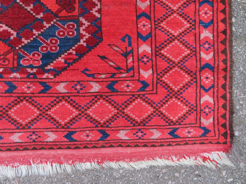 A large hand-knotted red wool Ersari carpet featuring repeating octagonal gul motifs and geometric border bands. View XII