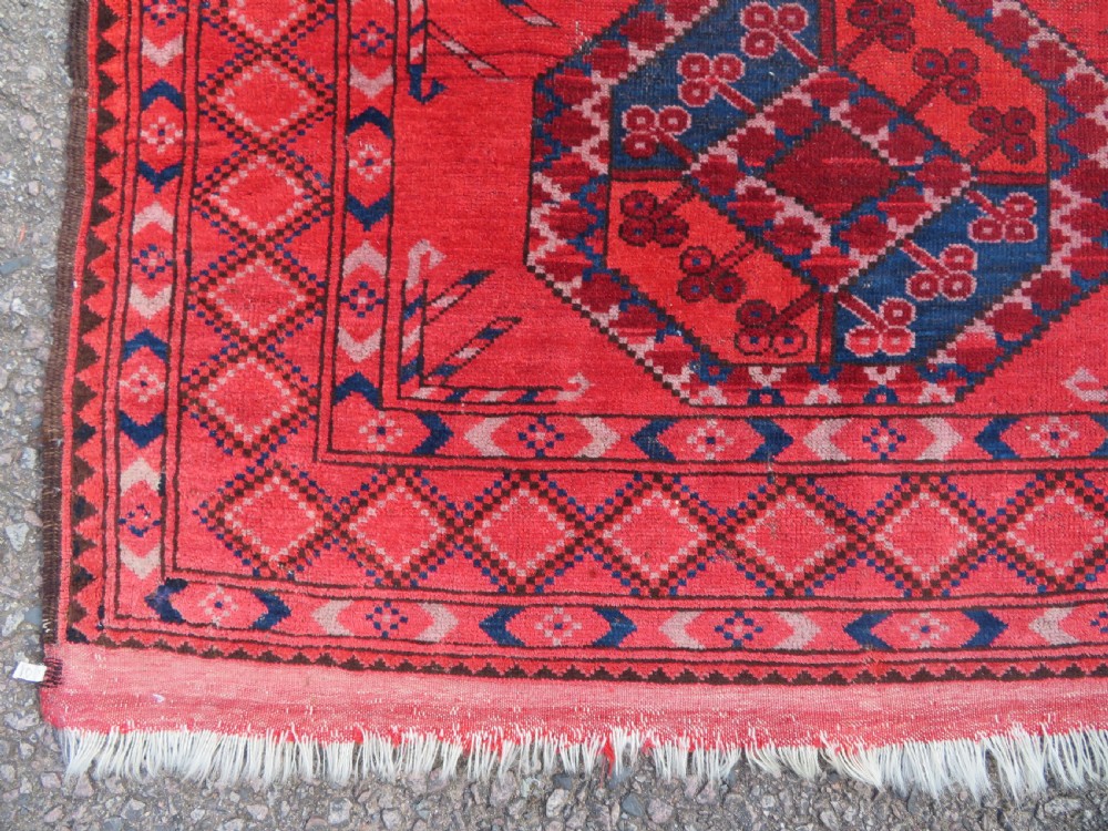 A large hand-knotted red wool Ersari carpet featuring repeating octagonal gul motifs and geometric border bands. View XIII