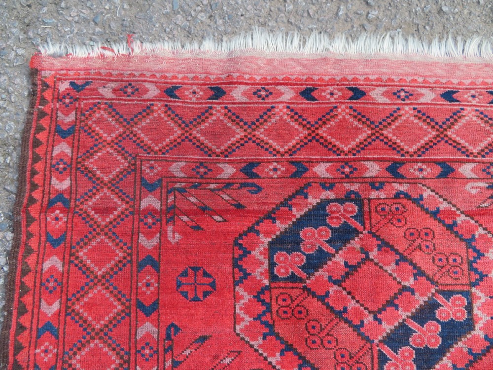 A large hand-knotted red wool Ersari carpet featuring repeating octagonal gul motifs and geometric border bands. View XV