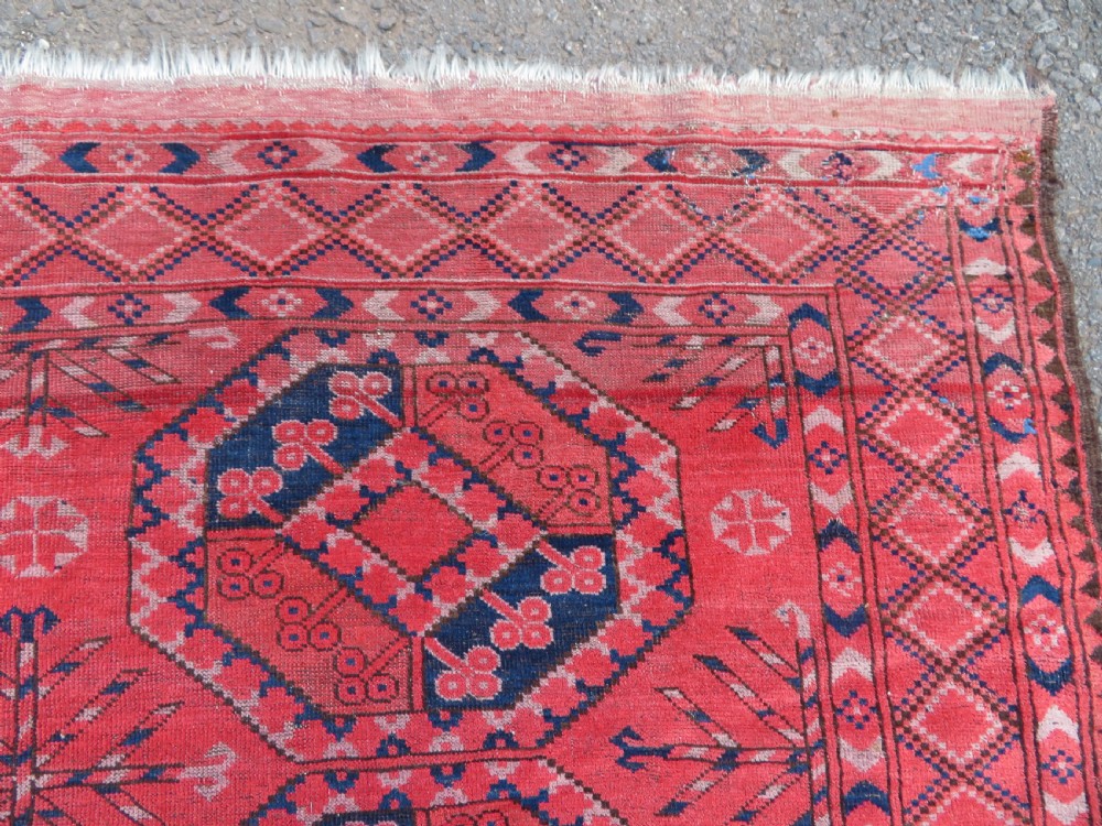 A large hand-knotted red wool Ersari carpet featuring repeating octagonal gul motifs and geometric border bands. View XVI
