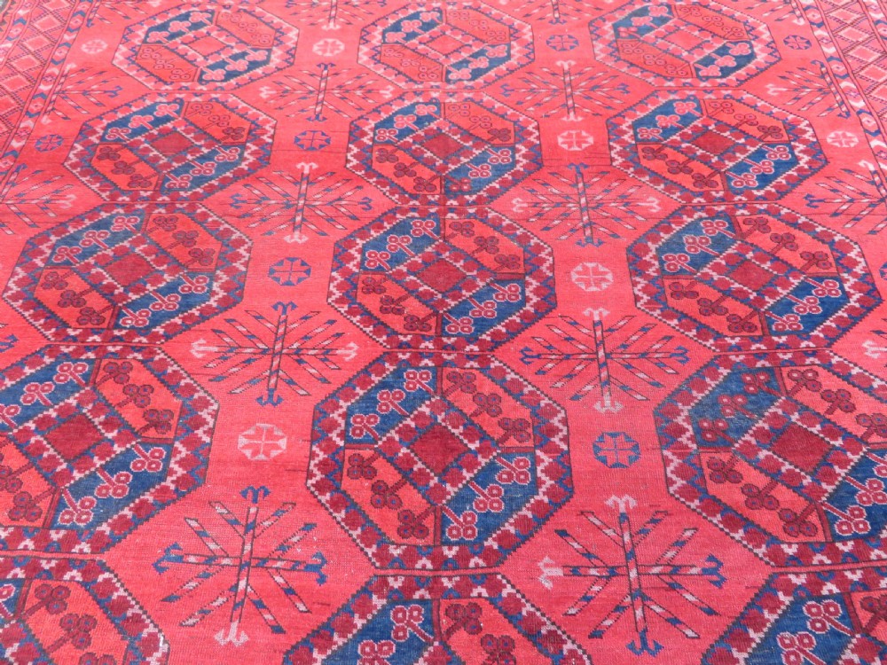 A large hand-knotted red wool Ersari carpet featuring repeating octagonal gul motifs and geometric border bands. View XX