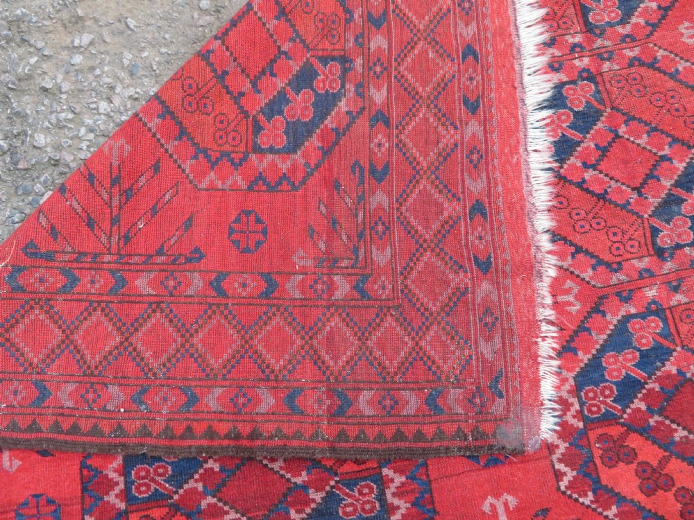 A large hand-knotted red wool Ersari carpet featuring repeating octagonal gul motifs and geometric border bands. View XXII