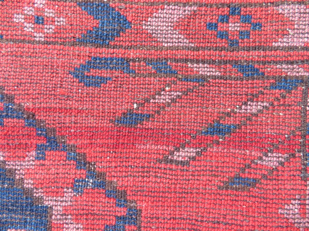 A large hand-knotted red wool Ersari carpet featuring repeating octagonal gul motifs and geometric border bands. View XXIV