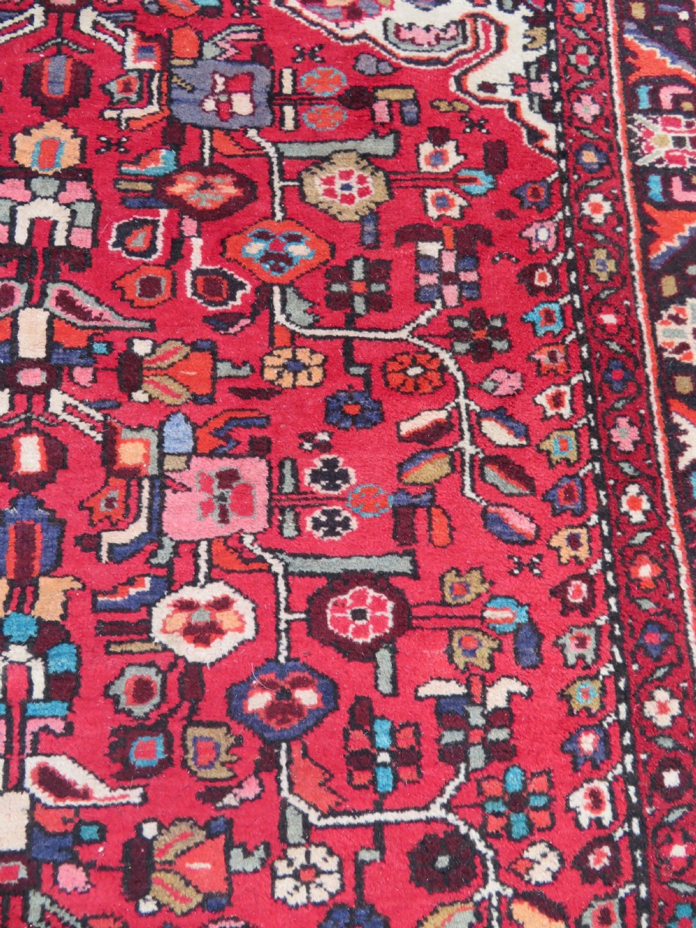 A long hand-knotted Persian Hamadan Kelleh carpet featuring a central cream medallion surrounded by geometric and floral motifs on a red field with multi-tiered borders. View IX