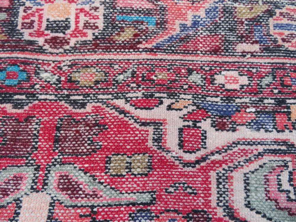 A long hand-knotted Persian Hamadan Kelleh carpet featuring a central cream medallion surrounded by geometric and floral motifs on a red field with multi-tiered borders. View XVI