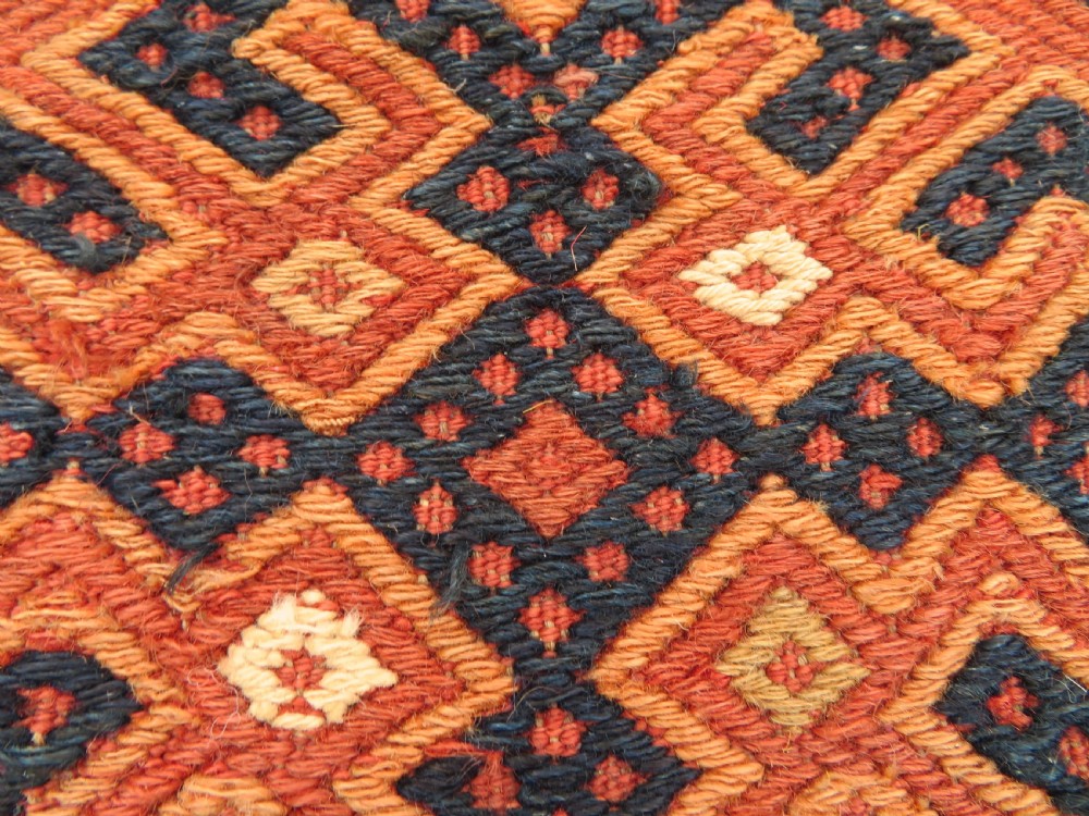 An Ersari Turkmen flatweave wool torba featuring geometric motifs in terracotta red, navy, and ivory, complete with a long fringed lower border. View II