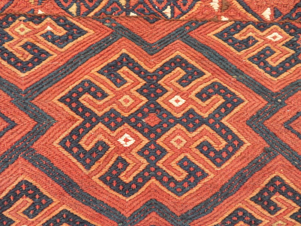 An Ersari Turkmen flatweave wool torba featuring geometric motifs in terracotta red, navy, and ivory, complete with a long fringed lower border. View III