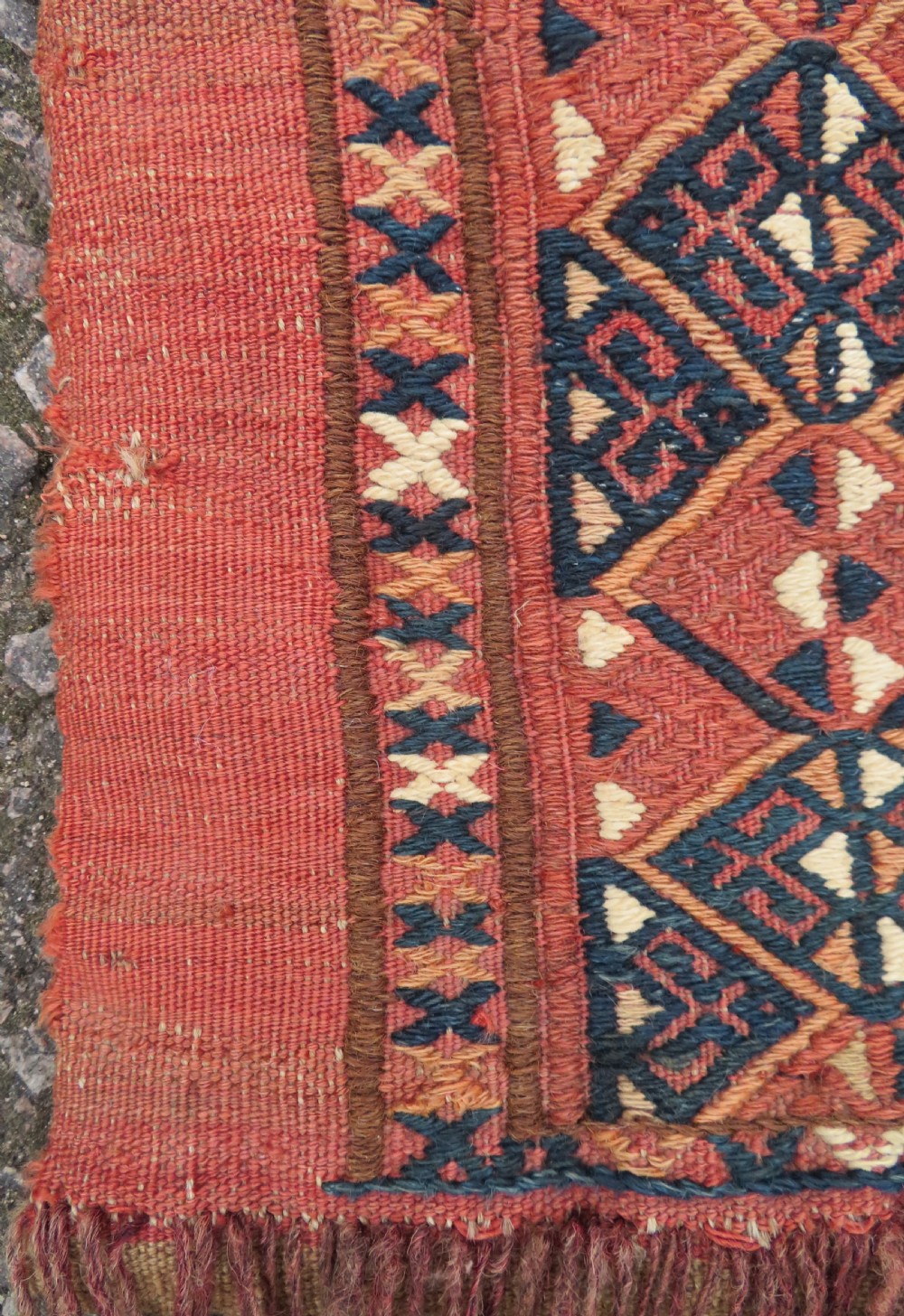 An Ersari Turkmen flatweave wool torba featuring geometric motifs in terracotta red, navy, and ivory, complete with a long fringed lower border. View VI