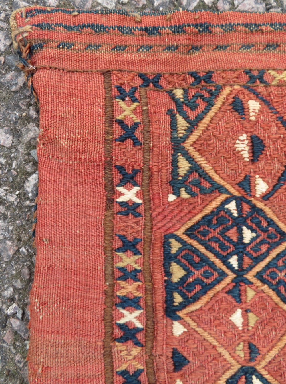 An Ersari Turkmen flatweave wool torba featuring geometric motifs in terracotta red, navy, and ivory, complete with a long fringed lower border. View VII