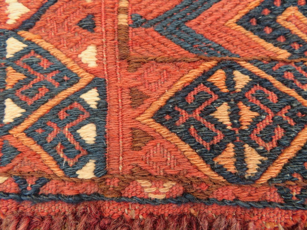 An Ersari Turkmen flatweave wool torba featuring geometric motifs in terracotta red, navy, and ivory, complete with a long fringed lower border. View VIII