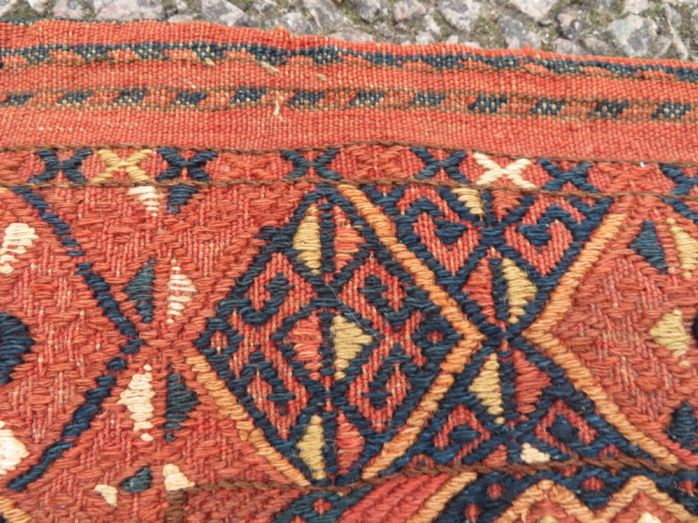 An Ersari Turkmen flatweave wool torba featuring geometric motifs in terracotta red, navy, and ivory, complete with a long fringed lower border. View IX