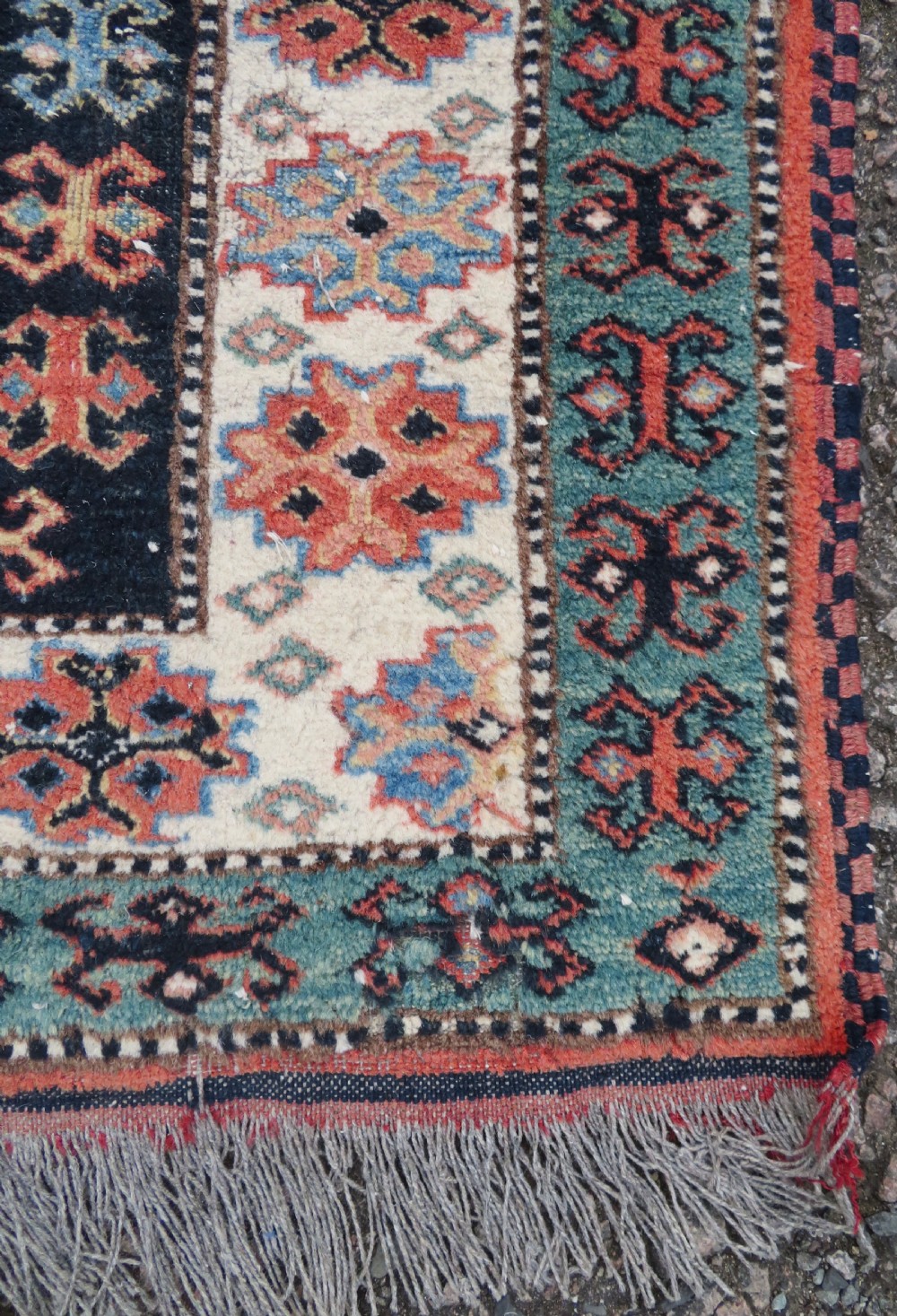 A handwoven rectangular wool rug featuring a central navy blue stepped medallion and a terracotta field decorated with peacock and animal motifs. View XIII