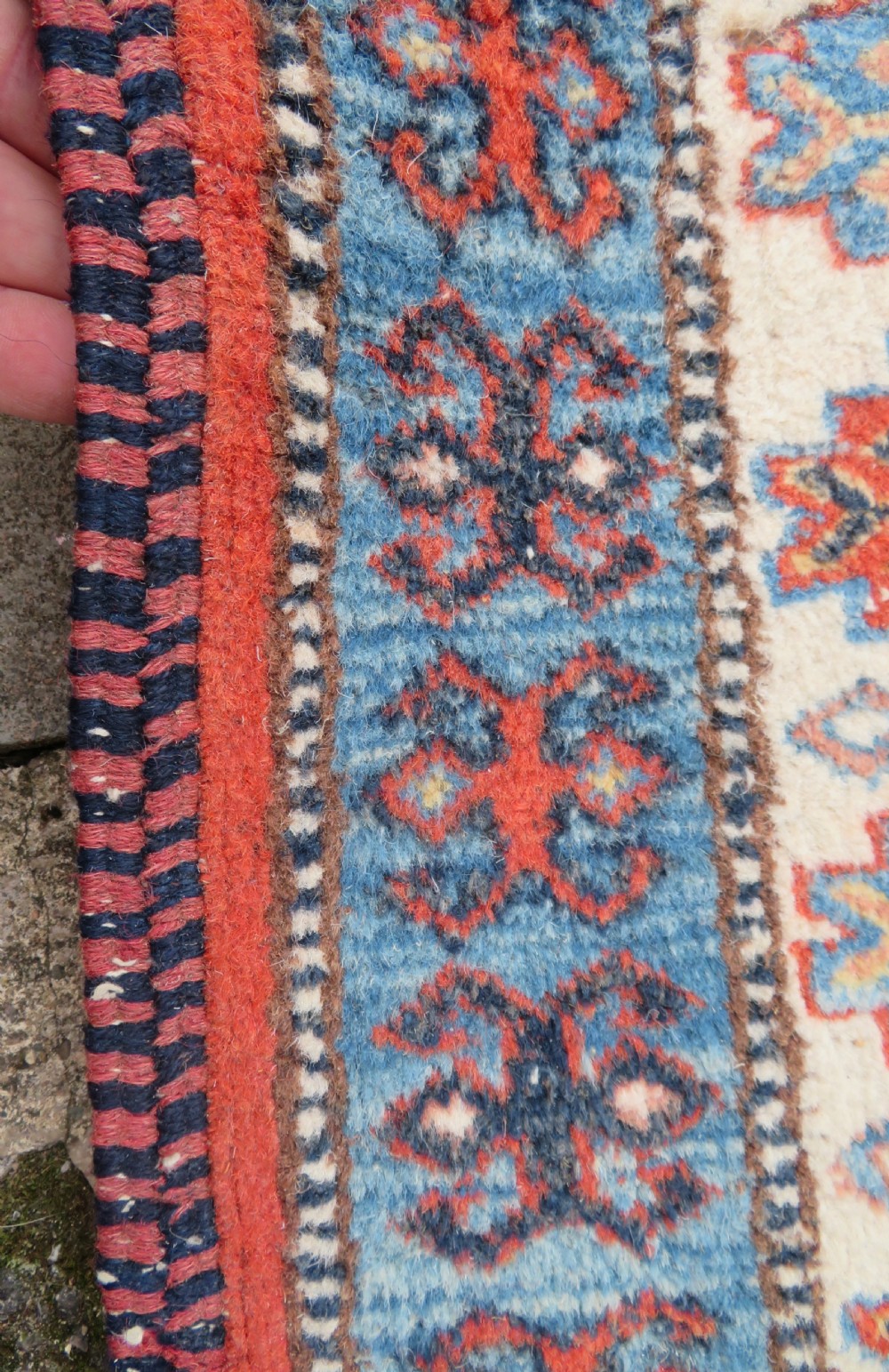 A handwoven rectangular wool rug featuring a central navy blue stepped medallion and a terracotta field decorated with peacock and animal motifs. View XVI