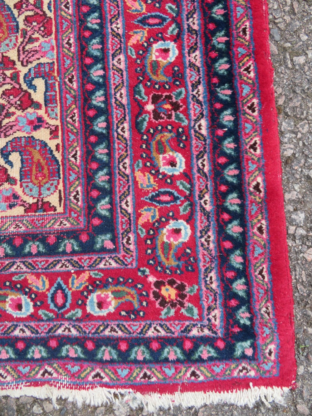 An antique Persian Meshed Doroksh wool rug featuring a repeating all-over boteh pattern on a cream field within multi-banded crimson and navy borders. View VI
