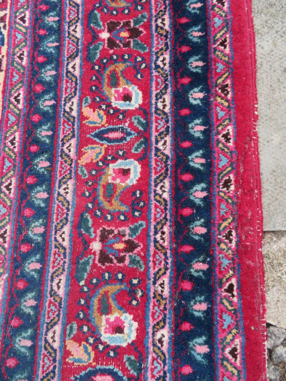An antique Persian Meshed Doroksh wool rug featuring a repeating all-over boteh pattern on a cream field within multi-banded crimson and navy borders. View XI