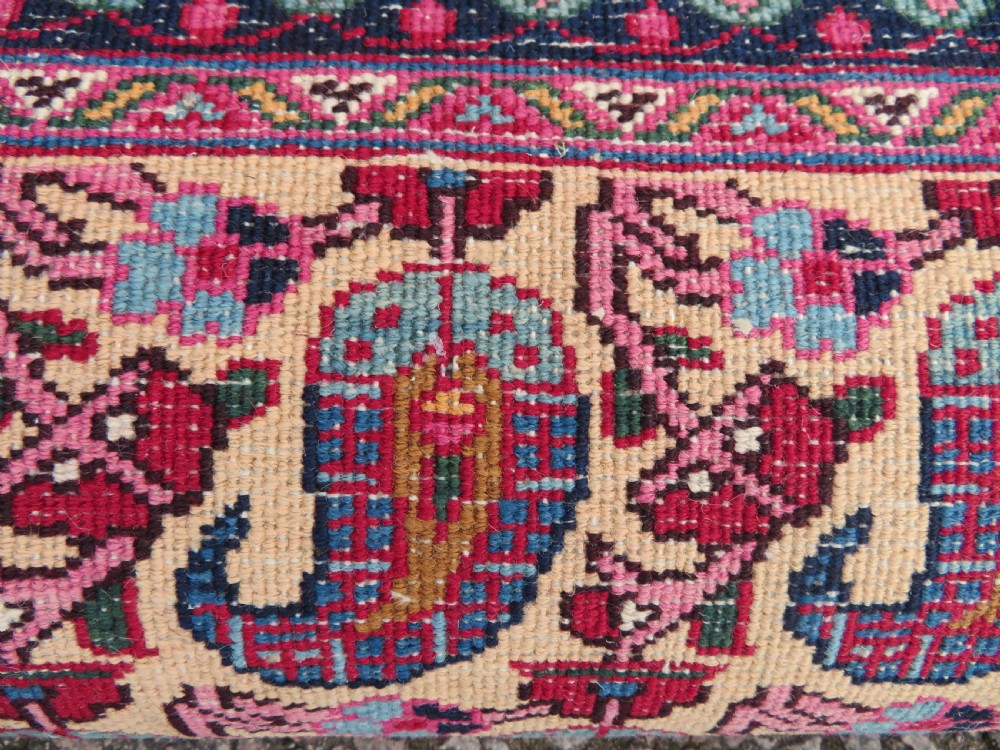 An antique Persian Meshed Doroksh wool rug featuring a repeating all-over boteh pattern on a cream field within multi-banded crimson and navy borders. View XVII