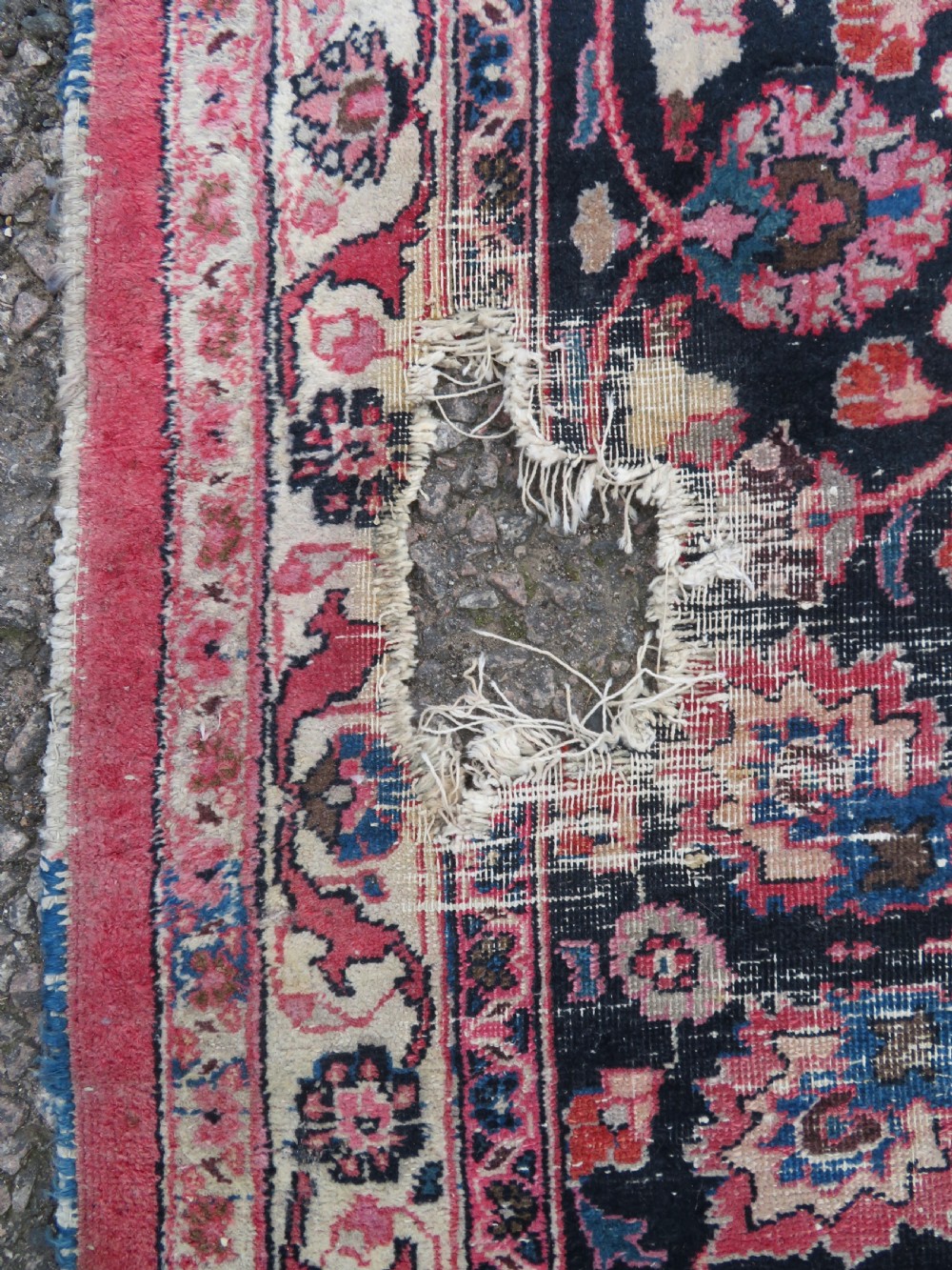 A large hand-knotted Persian Sarouk wool carpet featuring a distressed rose red field, central floral medallion, and deep navy blue floral borders. View XI