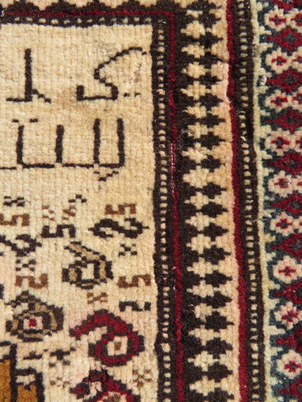 Hand-knotted wool Baluch prayer rug with a cream field featuring stylized camels, birds, hand symbols, and a mihrab top border. View VI