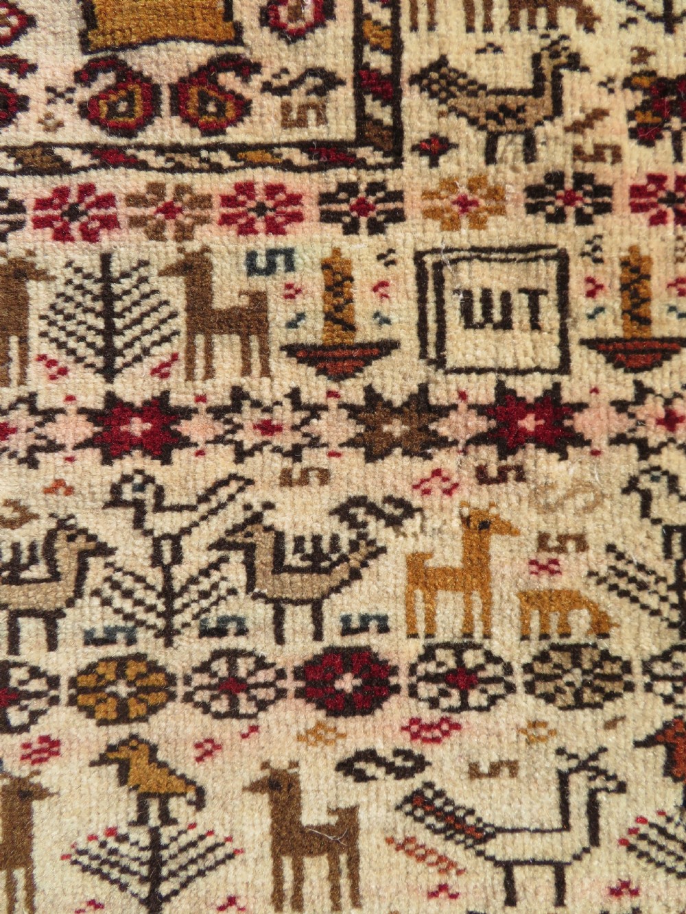 Hand-knotted wool Baluch prayer rug with a cream field featuring stylized camels, birds, hand symbols, and a mihrab top border. View VII