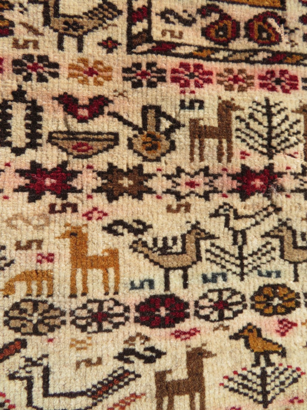 Hand-knotted wool Baluch prayer rug with a cream field featuring stylized camels, birds, hand symbols, and a mihrab top border. View VIII
