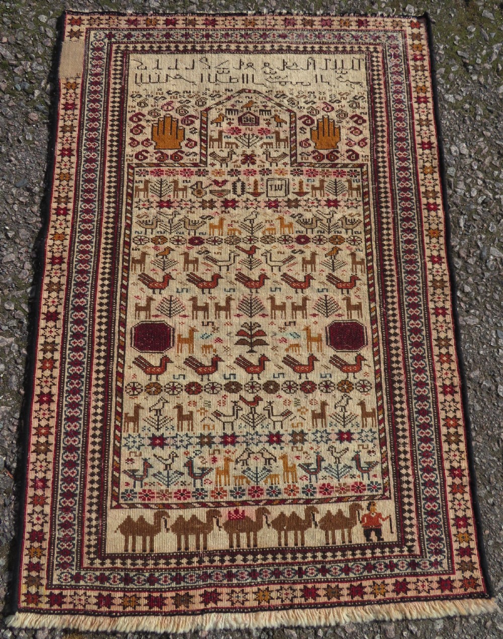 Hand-knotted wool Baluch prayer rug with a cream field featuring stylized camels, birds, hand symbols, and a mihrab top border. View IX
