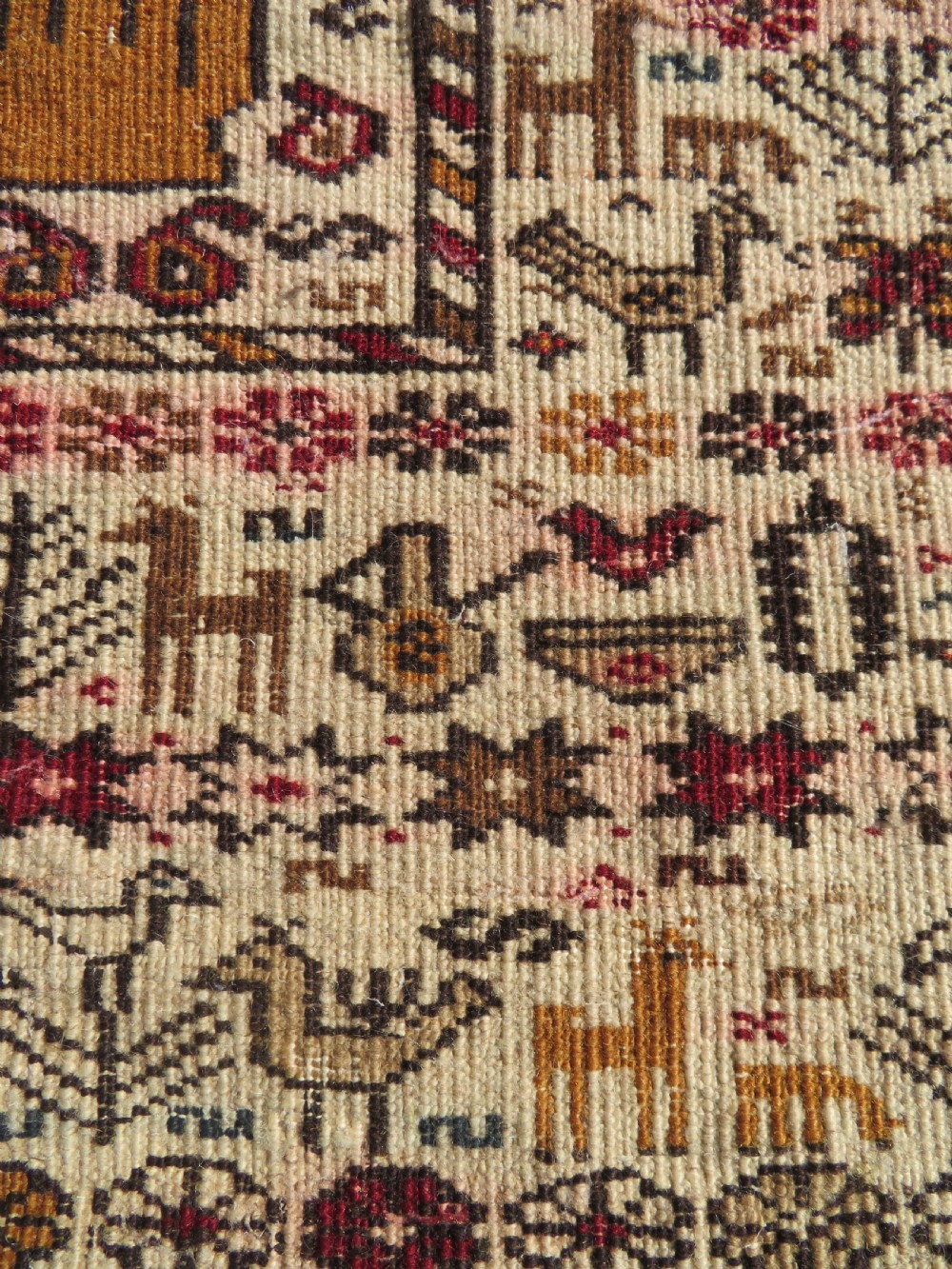 Hand-knotted wool Baluch prayer rug with a cream field featuring stylized camels, birds, hand symbols, and a mihrab top border. View XII