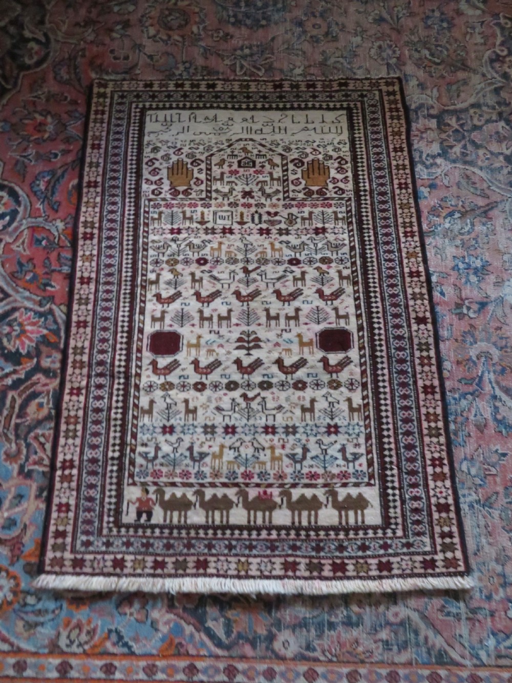 Hand-knotted wool Baluch prayer rug with a cream field featuring stylized camels, birds, hand symbols, and a mihrab top border. View XV